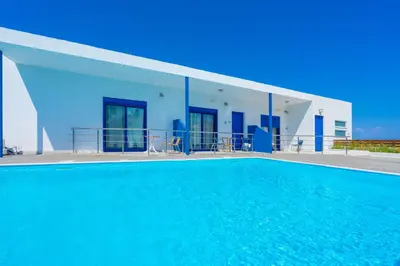 a swimming pool in front of a house at Raffaello Beach in Faliraki