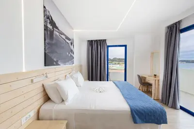 a bedroom with a bed with a view of the ocean at Raffaello Beach in Faliraki