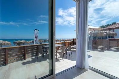 a balcony with a table and chairs and the ocean at Raffaello Beach in Faliraki