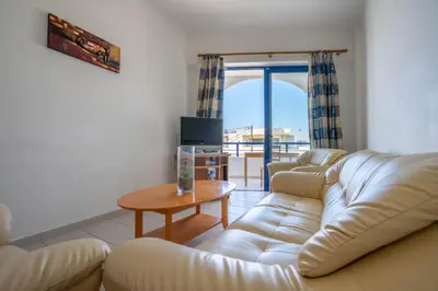 a living room with a couch and a table at Raffaello Beach in Faliraki