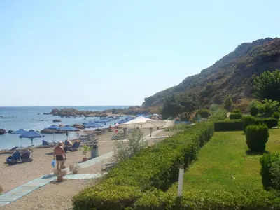 a beach with umbrellas and people on the beach at Elpida Beach Studios in Faliraki