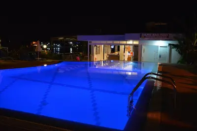 a large swimming pool at night with blue lights at Elpida Beach Studios in Faliraki