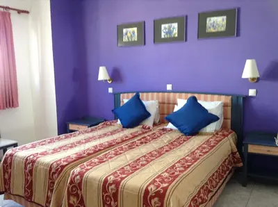 a hotel room with a large bed with blue pillows at Arte Annapolis Inn in Rhodes Town