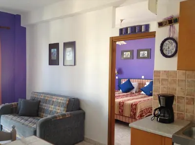 a bedroom with a bed and a couch and a mirror at Arte Annapolis Inn in Rhodes Town