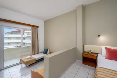 a small room with a bed and a window at Bayside Hotel Katsaras in Kremasti