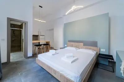 a bedroom with a large bed with white sheets at Alley 7, Old Town in Rhodes Town