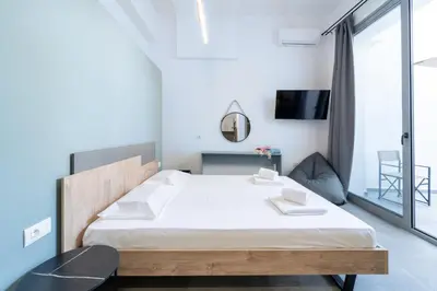 a bedroom with a bed and a desk and a tv at Alley 7, Old Town in Rhodes Town
