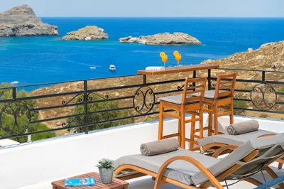 a balcony with chairs and a view of the ocean at Lindos Shore Boutique Villa with sea view in Líndos