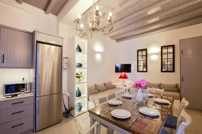 a kitchen and dining room with a table and a refrigerator at Lindos Shore Boutique Villa with sea view in Líndos