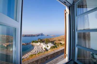 a window view of a beach and the ocean at Lindos Shore Boutique Villa with sea view in Líndos