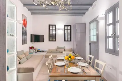 a dining room with a table and a living room at Lindos Shore Boutique Villa with sea view in Líndos