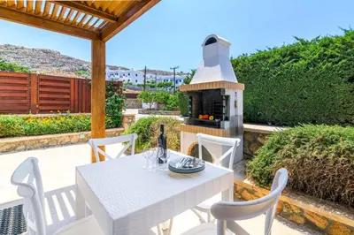 a white table and chairs on a patio with a stove at Lindos Ruby in Líndos