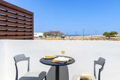 a table and chairs on a balcony with a view of the beach at Lindos Ruby in Líndos