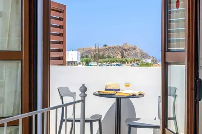 a balcony with a table with a hat on it at Lindos Ruby in Líndos