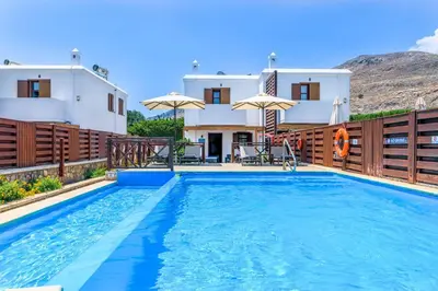 a villa with a swimming pool in front of a house at Lindos Ruby in Líndos