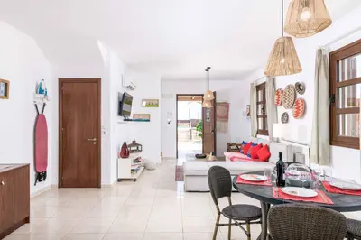 a kitchen and living room with a table and chairs at Lindos Ruby in Líndos