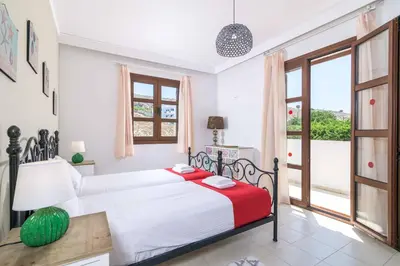 a bedroom with a bed with a red and white blanket at Lindos Ruby in Líndos