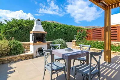a patio with a table and chairs and a fireplace at Lindos Sapphire in Líndos