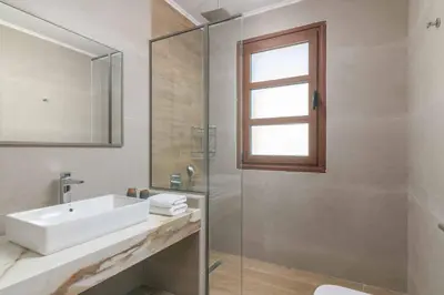 a bathroom with a sink and a glass shower at Lindos Sapphire in Líndos