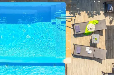 an overhead view of a swimming pool with chairs at Lindos Sapphire in Líndos