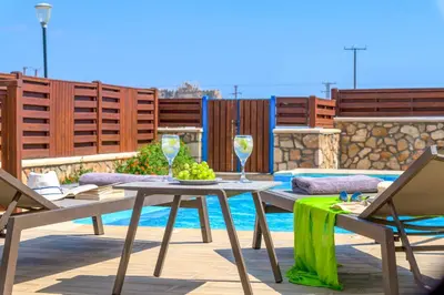 a table and chairs with wine glasses on a patio at Lindos Sapphire in Líndos