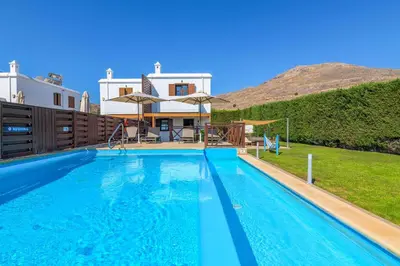 a villa with a swimming pool in front of a house at Lindos Topaz in Líndos
