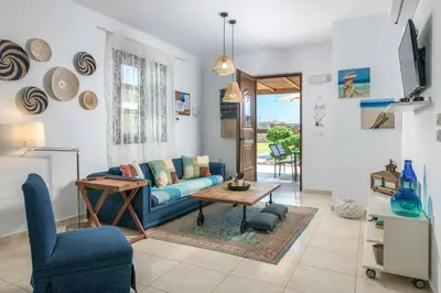 a living room with a blue couch and a table at Lindos Topaz in Líndos
