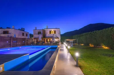 a villa with a swimming pool at night at Lindos Topaz in Líndos