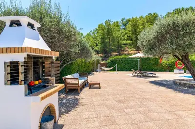 a patio with a fireplace and a hammock at Villa Krini Selini in vlicha