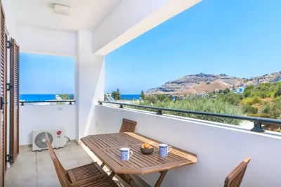 a balcony with a table and chairs and a window at Villa Krini Selini in vlicha