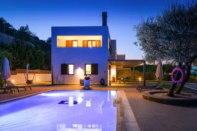 a house with a swimming pool in front of a house at Villa Krini Selini in vlicha