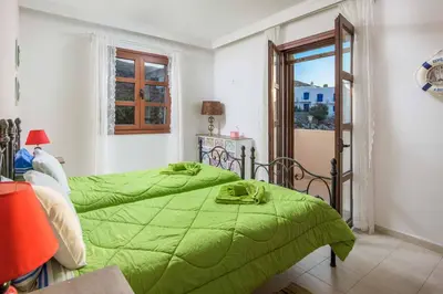 a bedroom with a green bed and a window at Lindos Emerald in Líndos