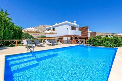 a villa with a swimming pool and a house at Lindos Emerald in Líndos