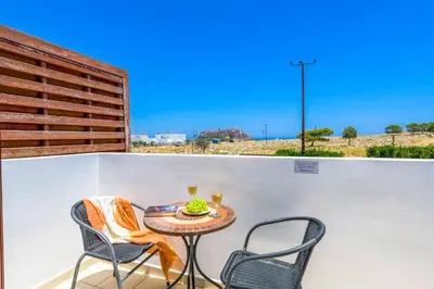 a small table and two chairs on a balcony at Lindos Emerald in Líndos