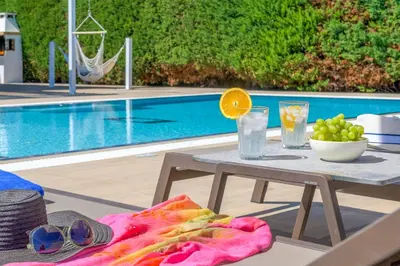 a table with a bowl of fruit next to a pool at Villa Krini Eleni in vlicha