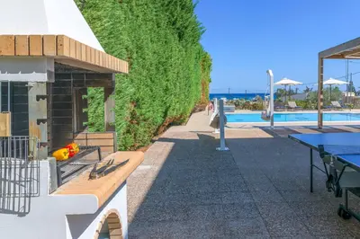 a swimming pool with a bench next to a building at Villa Krini Eleni in vlicha
