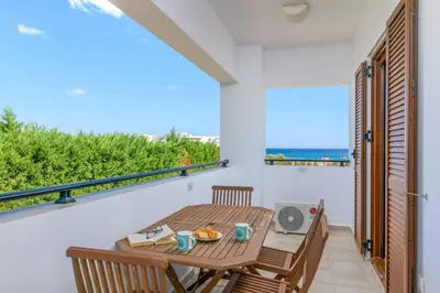 a balcony with a table and chairs and a view of the ocean at Villa Krini Eleni in vlicha