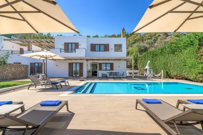 a villa with a swimming pool in front of a house at Villa Krini Eleni in vlicha