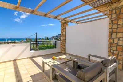 a patio with a bench and a view of the ocean at Villa Krini Eleni in vlicha