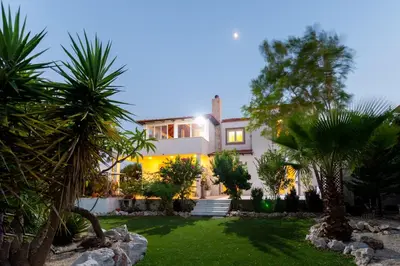 a house with palm trees in front of it at Nicole's garden villa in Kallithea Rhodes
