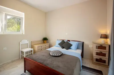 a bedroom with a large bed and a window at Nicole's garden villa in Kallithea Rhodes