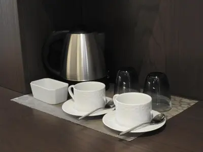 two cups and saucers on a table with a coffee pot at Nikos Ikies in Theologos