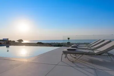 a row of lounge chairs sitting next to a swimming pool at Alav Pool Villa in Afantou