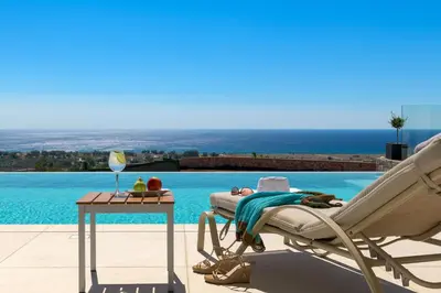 a lounge chair and a table next to a swimming pool at Alav Pool Villa in Afantou