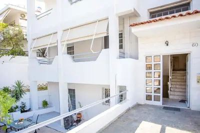 an exterior view of a white apartment building with a balcony at Flora's Place in Rhodes Town