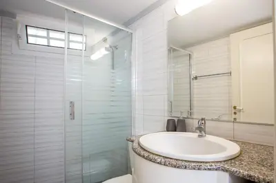 a bathroom with a sink and a glass shower at Flora's Place in Rhodes Town
