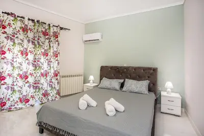 a bedroom with a bed with two white towels on it at Flora's Place in Rhodes Town