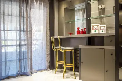 a kitchen with a bar with two yellow stools at Flora's Place in Rhodes Town