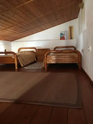 two beds in a room with a rug on the floor at Casa Kalliroi in Symi