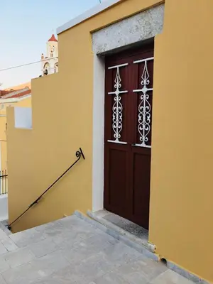 a brown door on the side of a building at Casa Kalliroi in Symi